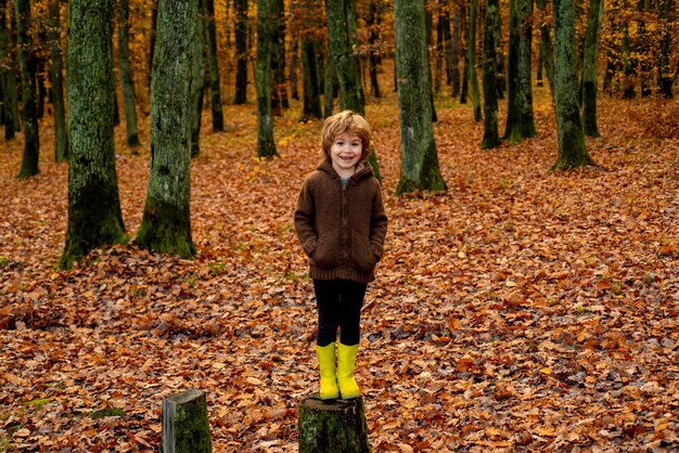 Nettes Kind in Vintage-Kleidung auf Herbstlaub Hintergrund schöne Herbstzeit in der Natur