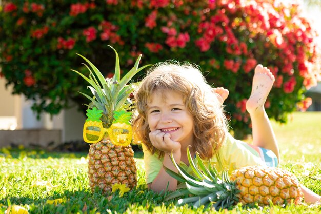 Nettes Kind mit frischen tropischen Früchten der Ananas für gesunden Lebensstil der Kinder mit frischen Bio-Früchten