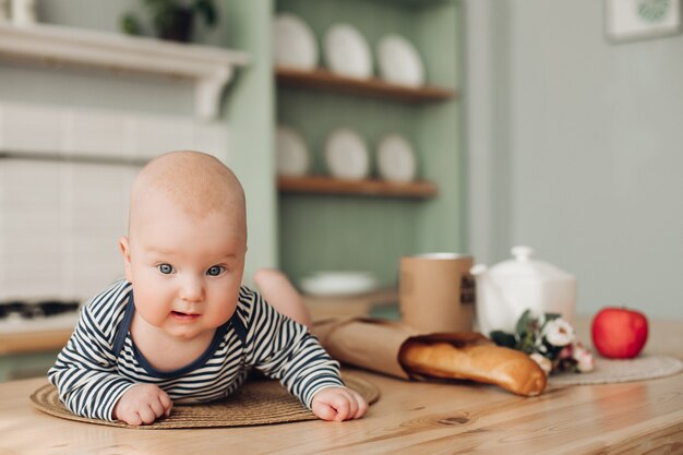 Nettes Kind mit großen blauen Augen, die auf sein Essen warten.