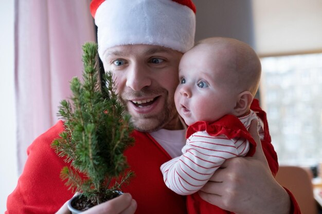 Nettes Kind und ihr Vater mit Weihnachtsbaum