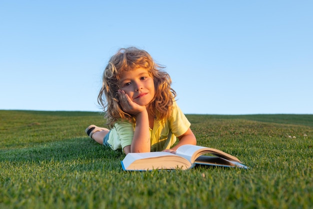 Nettes Kinderlesebuch draußen im Sommerpark auf Gras