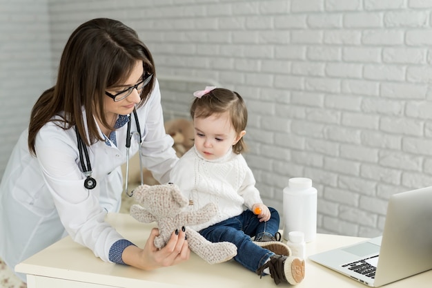 Nettes Kindermädchen, das Arzt mit Plüschtier spielt