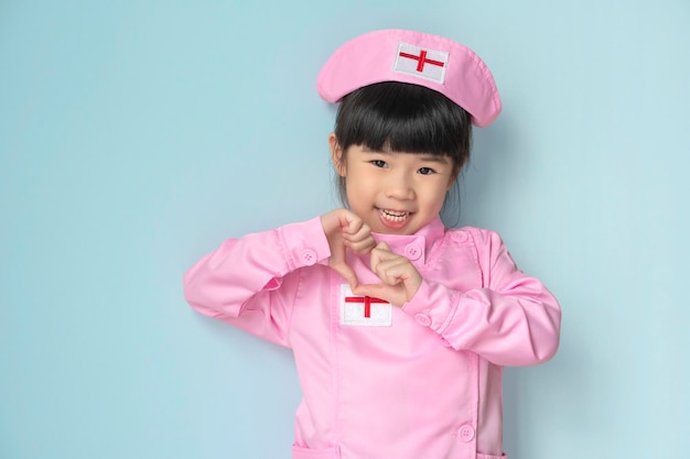 Nettes kleines asiatisches Mädchen, das als Krankenschwester spielt und ihre Liebe zeigt