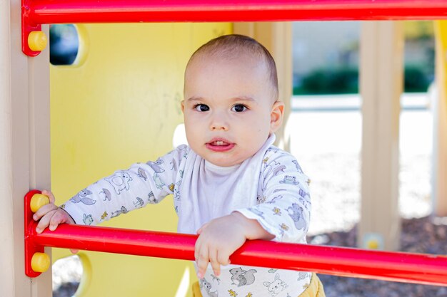 Nettes kleines Baby, das am Kinderspielplatz spielt. Wandern mit Kind im Freien