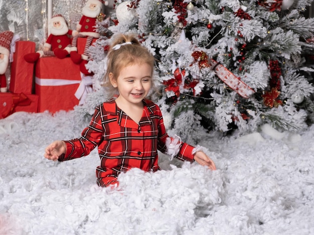 Nettes kleines Baby, das Spaß im weihnachtlich dekorierten Raumkonzept der frohen Weihnachten hat