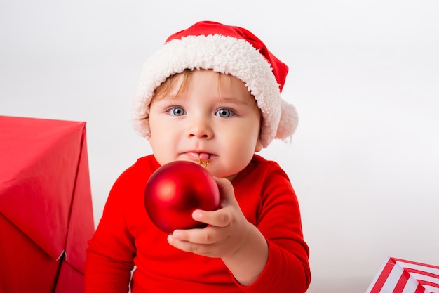 Nettes kleines Baby in einem Santa Kostüm mit Geschenken