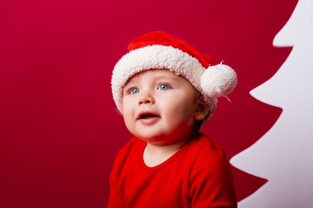 Nettes kleines Baby mit einer Weihnachtsmütze