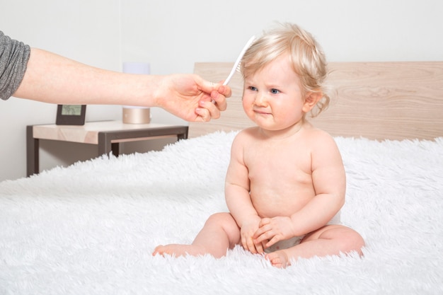 Nettes kleines baby mit kamm im elternschlafzimmer.