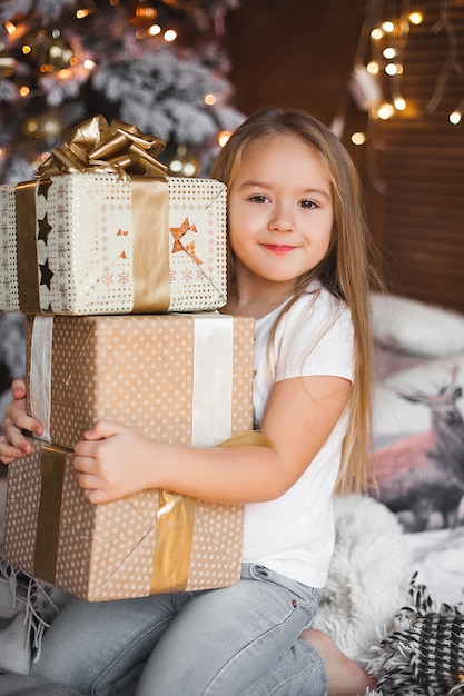 Nettes kleines Kind, das Weihnachtsgeschenke hält