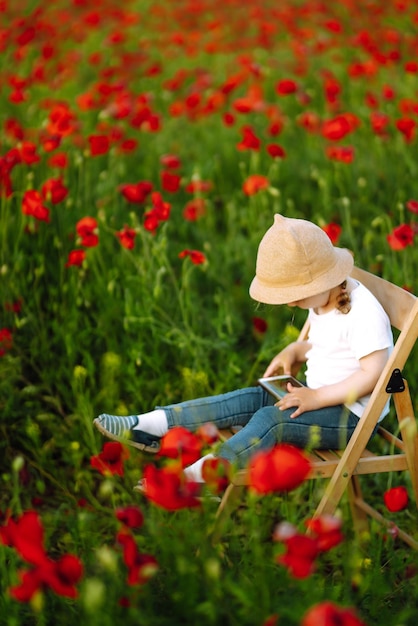 Nettes kleines Kind Mädchen im Mohnfeld Entzückendes Kind, das auf sonnigem Feld spielt