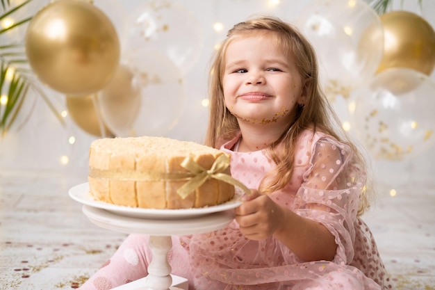 Nettes kleines Kindermädchen, das Geburtstagskuchen ohne Hand isst und Geburtstag feiert