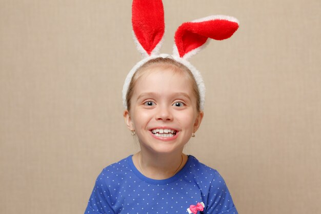 Nettes kleines Kindermädchen, das Hasenohren am Ostertag trägt.