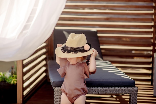 Nettes kleines Mädchen 1 Jahr alt am Strand des Resorts im Sommer in einem trendigen Outfit