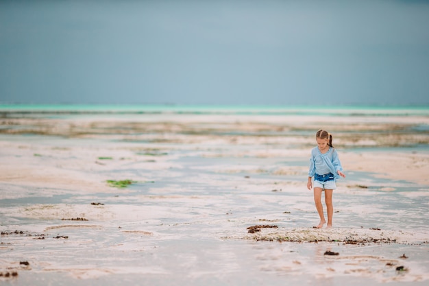 Nettes kleines Mädchen am Strand während der Sommerferien