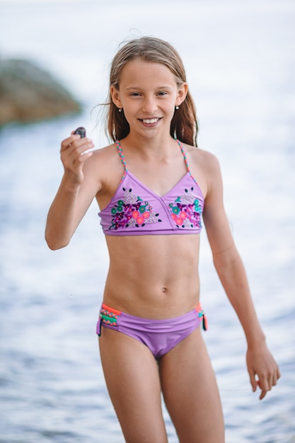 Foto nettes kleines mädchen am strand während der sommerferien