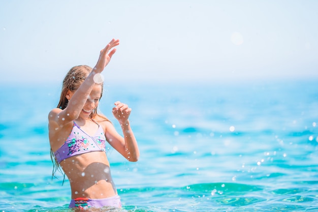 Nettes kleines Mädchen am Strand während der Sommerferien