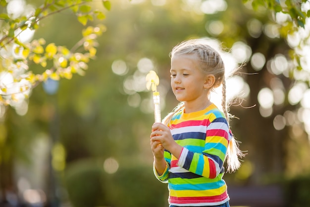Nettes kleines Mädchen auf einem Spaziergang in einer mehrfarbigen gestrickten Bluse