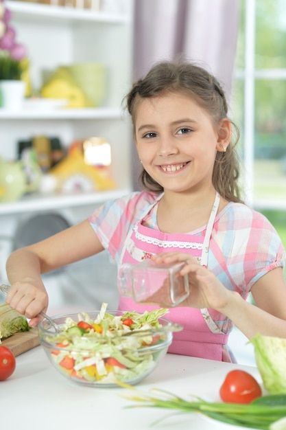 Nettes kleines Mädchen, das Abendessen macht