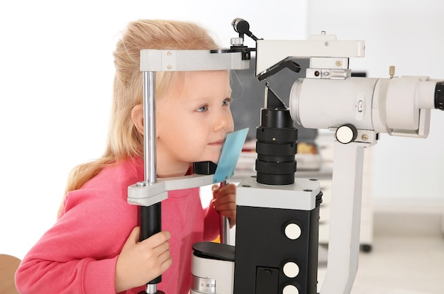 Foto nettes kleines mädchen, das den arzt der kinder besucht augenuntersuchung