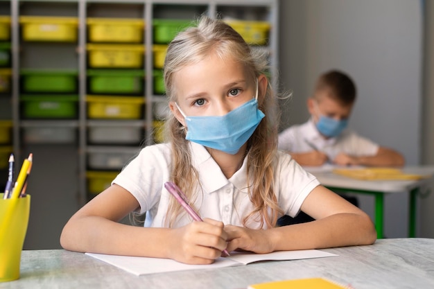 Foto nettes kleines mädchen, das eine medizinische maske trägt