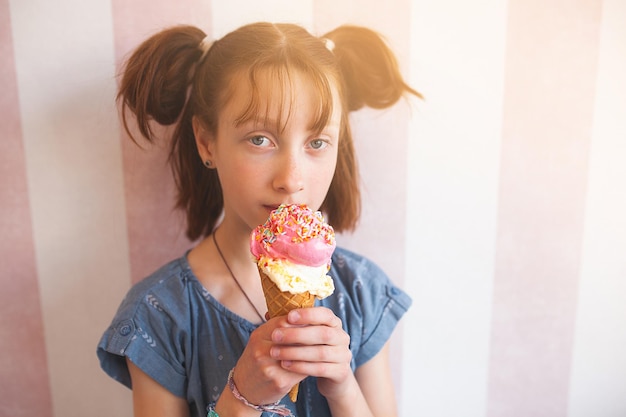 Nettes kleines Mädchen, das Eiscreme in der Cafeteria isst Kind, das Eis hält Kind und Süßigkeiten