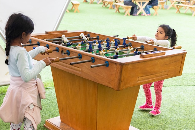 Nettes kleines Mädchen, das Tischfußball spielt