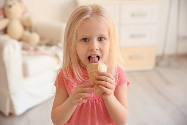 Nettes kleines Mädchen, das zu Hause Eis isst