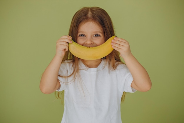 Nettes kleines Mädchen getrennt mit Banane