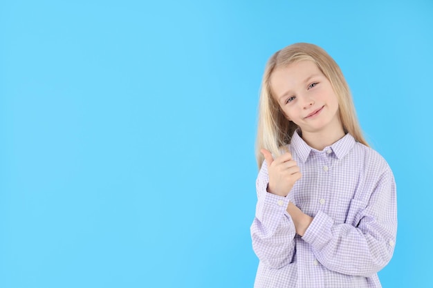 Nettes kleines Mädchen im Hemd auf blauem Hintergrund