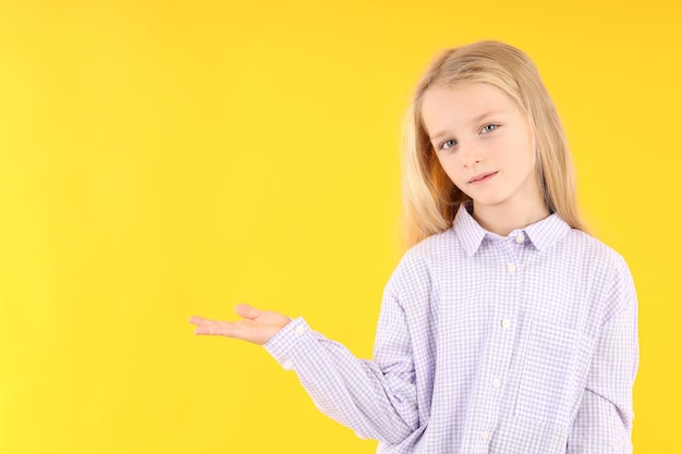 Nettes kleines Mädchen im Hemd auf gelbem Hintergrund
