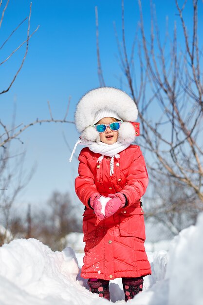 Nettes kleines Mädchen im Winter, viel Spaß