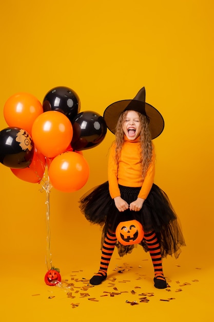 Nettes kleines Mädchen in einem Hexenkostüm für Halloween