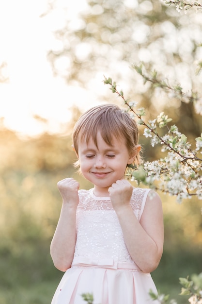 Nettes kleines Mädchen in einem rosa Kleid in der Natur