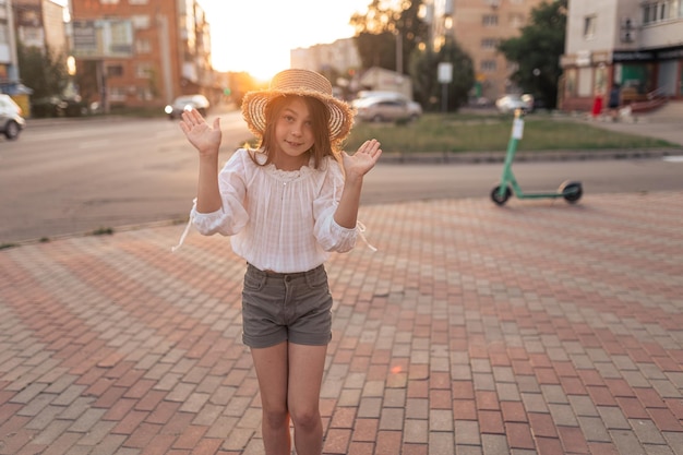 Nettes kleines Mädchen in einem Strohhut im Freien im Sommer