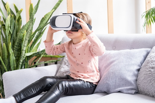 Nettes kleines Mädchen in Virtual-Reality-Brille zu Hause glückliches Kind mit VR-Headset