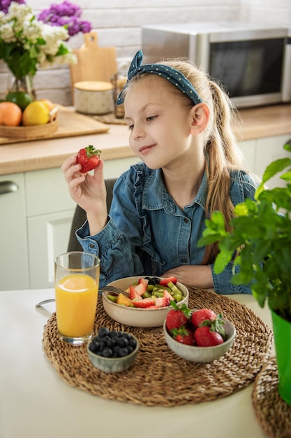 Nettes kleines Mädchen isst Obstsalat