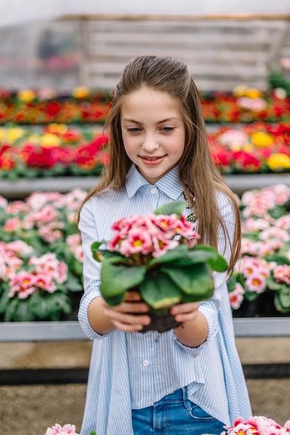 Nettes kleines Mädchen mit Blumen in ihren Händen