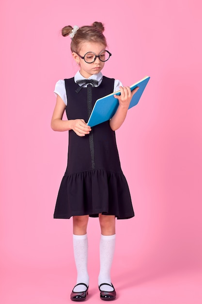 Nettes kleines Mädchen mit Brille und Büchern auf rosa Raum, Raum für Text. Lesekonzept