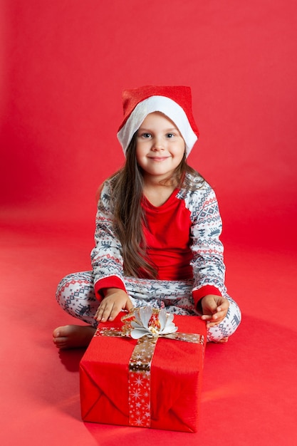 Nettes kleines Mädchen mit einem Weihnachtsgeschenk