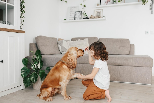 Nettes kleines Mädchen mit Hund zu Hause