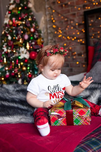 Nettes kleines Mädchen mit Weihnachtsgeschenken