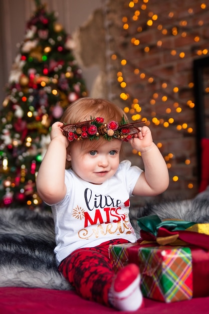 Nettes kleines Mädchen mit Weihnachtsgeschenken