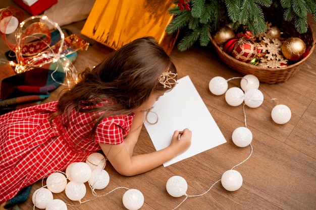 Nettes kleines Mädchen schreibt Brief an den Weihnachtsmann