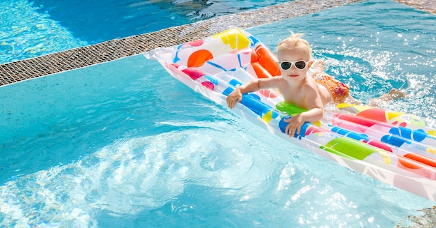 Nettes kleines Mädchen schwimmt auf einer Luftmatratze im Pool Beschneidungspfad eingeschlossen. Kopieren Sie Platz.