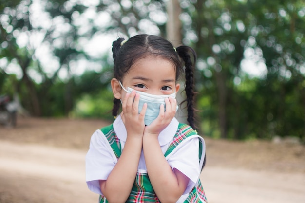 Nettes kleines Mädchen tragen Maske zum Schutz Coronavirus oder covid 19.