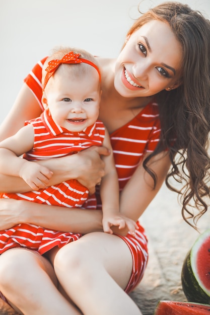 Nettes kleines Mädchen und ihre Mutter zusammen im Freien. Mama und ihr Kind lächeln und haben Spaß zusammen. Liebenswerte Familie.