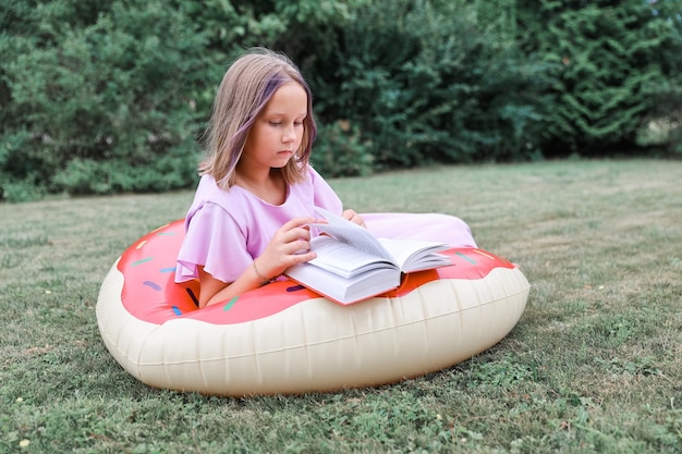 Nettes kleines Mädchenlesebuch draußen. Ruhe im Sommer