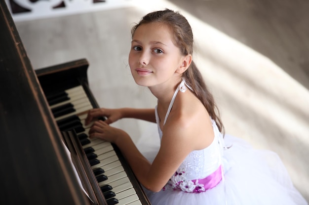 Nettes kleines Prinzessinnenmädchen spielt Klavier im Studio