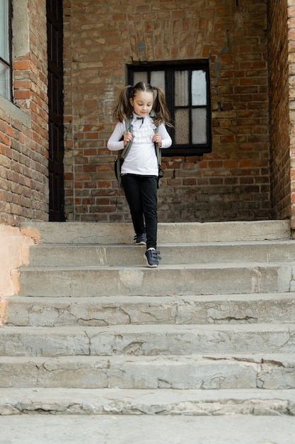 Nettes kleines Schulmädchen in ihrer Uniform draußen