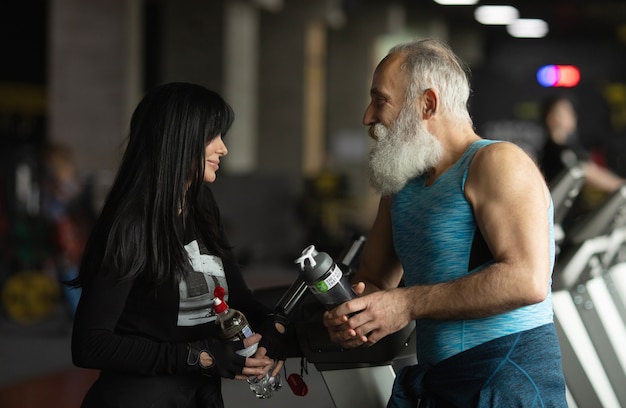 Nettes lächelndes älteres Paar, das im Fitnessstudio trainiert.